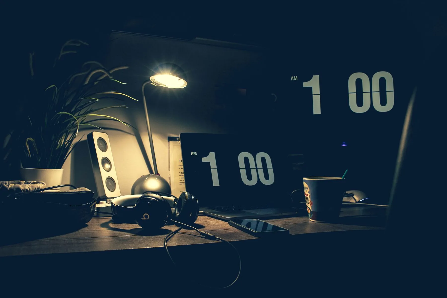 Bureau de travail le soir, ordinateur portable et lampe allumée